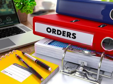 Red Ring Binder with Inscription Orders on Background of Working Table with Office Supplies, Laptop, Reports. Toned Illustration. Business Concept on Blurred Background..jpeg