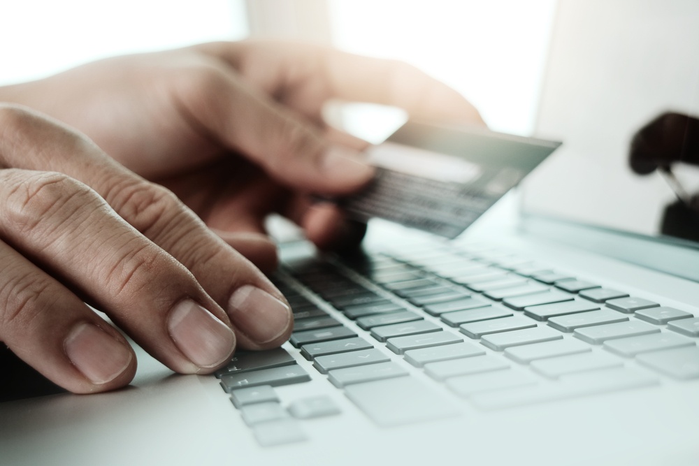close up of hands using laptop and holding credit card  as Online shopping concept.jpeg